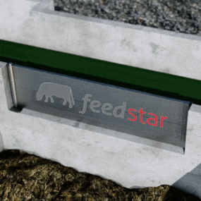 Detail close-up of aluminium flap edge pushing off remaining feed from belt into collection pit
